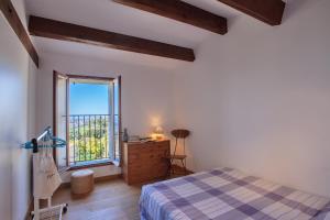 Schlafzimmer mit einem Bett und einem Fenster in der Unterkunft Casa Poggio in Barbaggio
