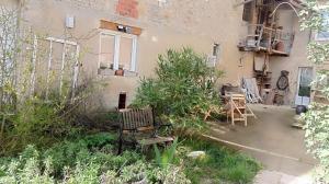 Un patio con un banco frente a un edificio. en Idha à proximité de Bayeux, en Vaucelles