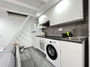 a kitchen with a washing machine and a sink at Encantador Madrid Val Izq in Madrid