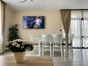 uma sala de jantar com uma mesa branca e cadeiras em Къща за гости ЕМ Парадайс em Tserova Koriya