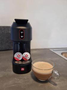Julietta Suites في أرغوستولي: آلة صنع القهوة على منضدة مع كوب من القهوة