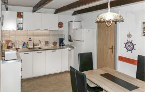 eine Küche mit weißen Schränken und einem Tisch mit Stühlen in der Unterkunft 2 Bedroom Beautiful Home In Heidesee in Heidesee