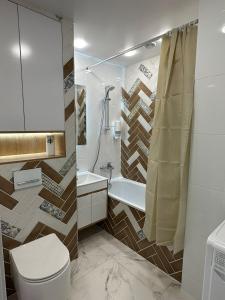 y baño con aseo, lavabo y ducha. en Nursultana Nazarbaeva 20 Str by Slissenko Inn, en Pavlodar