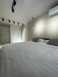 1 dormitorio con 1 cama blanca grande y 2 almohadas en Nursultana Nazarbaeva 20 Str by Slissenko Inn en Pavlodar