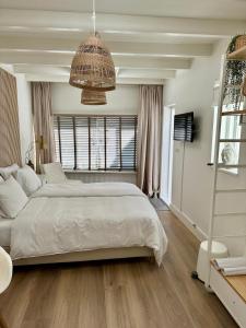 a bedroom with a large bed and a large window at Oranje Nassau aan Zee Studio in Zandvoort