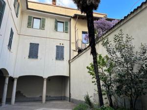 un edificio con una palmera delante de él en Loft Matteotti - Studio in centro, en Busto Arsizio