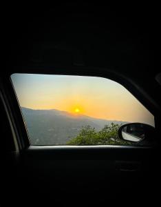 a view of a sunset from a car window at Forest Cabin Bugyal Stays in Pauri +33 photos