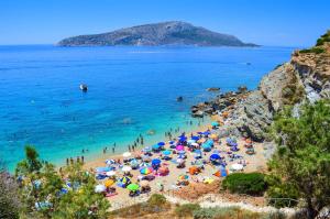 a beach with a bunch of people with umbrellas at Harmony 2 in Gold in Lavrio