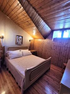 una camera da letto con un grande letto in una camera in legno di Peace and Lake Mountain Lake Iseo Hospitality a Bossico