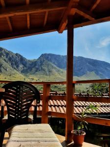 a table and chair on a porch with a view of mountains at Kerekes Vendégház in Rimetea