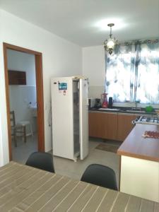 uma cozinha com um frigorífico e uma mesa com cadeiras em Cs6 Casa de 3 Quartos a 15min de Curitiba em Campina Grande do Sul