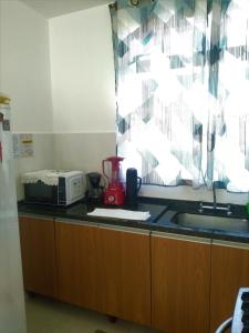 a kitchen with a counter with a sink and a window at Cs6 Casa de 3 Quartos a 15min de Curitiba in Campina Grande do Sul