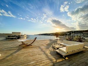 a deck with a couch and chairs on the water at Villa Marine - 10 pers - Centre Cassis - Piscine in Cassis