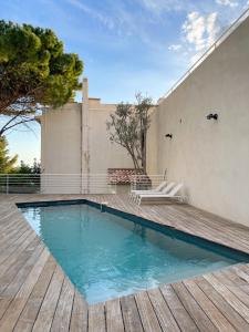 a swimming pool on a wooden deck next to a building at Villa Marine - 10 pers - Centre Cassis - Piscine in Cassis