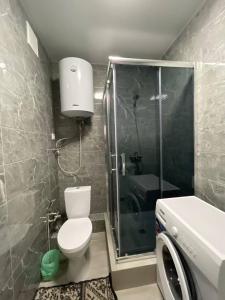 a bathroom with a shower and a toilet and a sink at Sea 406 in Odesa