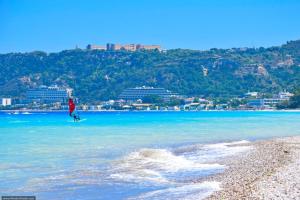 a person walking in the water on a beach at Sunwaves Beach studio I in Ialyssos