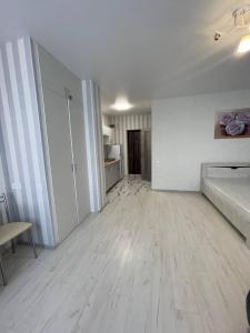 una sala de estar vacía con suelo de madera y paredes blancas en Sea 406, en Odessa