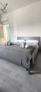 - une chambre avec un grand lit et une couverture grise dans l'établissement Welcome Migliarina 2, à La Spezia