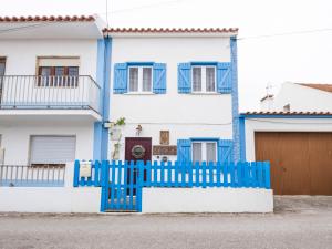 una recinzione blu di fronte a una casa bianca di Castaway a Baleal