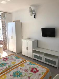 uma sala de estar com televisão e armários brancos em Canalex em Maspalomas
