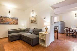 een woonkamer met een bank en een keuken bij DaLu Florence apartment Davide - private car park 15 minutes to the city center in Florence