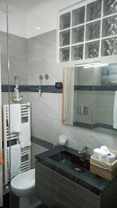 baño con lavabo negro y aseo en Casa Vacanze Villa Pompeiana, en Trieste