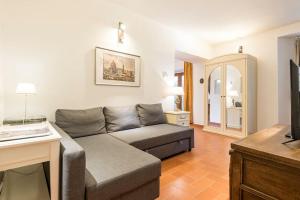 een woonkamer met een bank en een televisie bij DaLu Florence apartment Davide - private car park 15 minutes to the city center in Florence