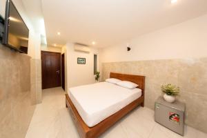 a bedroom with a bed and a tv in it at Saigon Cozy Hotel in Ho Chi Minh City