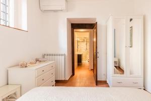 a white bedroom with a white bed and a hallway at DaLu Florence apartment Davide - private car park 15 minutes to the city center in Florence