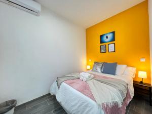 una camera con un letto con una parete gialla di Encantador Madrid Val Izq a Madrid