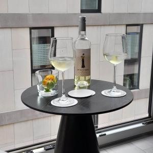 einen Tisch mit zwei Weingläsern und einer Flasche Wein in der Unterkunft Ostend Central Residence in Ostende