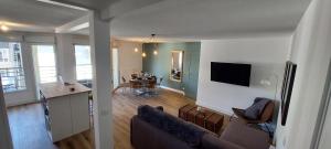 sala de estar y cocina con sofá y mesa en L'embarcadère Evian - Leman Odyssey, en Évian-les-Bains