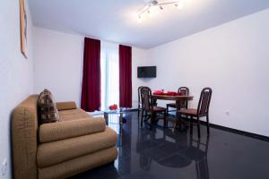 a living room with a dining room table and a chair at Apartments Ilak in Trogir