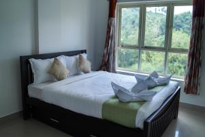 a bed in a room with a large window at Caravan holiday homes Vythiri in Vythiri