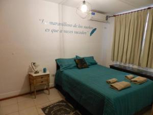 - une chambre avec un lit et une couette verte dans l'établissement Viví Rosario, à Rosario