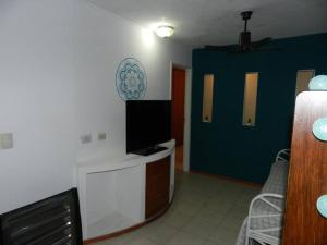 une chambre avec un lit et une télévision dans l'établissement Viví Rosario, à Rosario