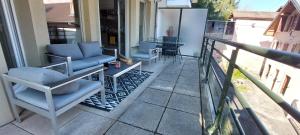 - une terrasse couverte avec des chaises et une table sur un balcon dans l'établissement L'embarcadère Evian - Leman Odyssey, à Évian-les-Bains