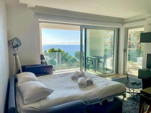 a bedroom with a large bed and a large window at Mont des Olives - Cap D'ail- app4 in Saint-Antoine