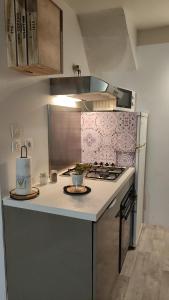 a kitchen with a stove and a counter top at Le cocoon de Christelle in Montredon