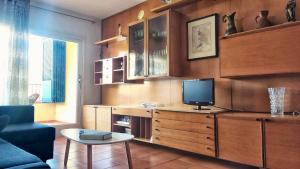 a living room with a tv on a wooden dresser at Feliz Costa Brava Apartamento in Portbou