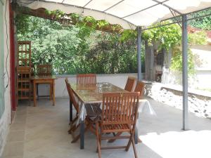 een patio met een tafel en stoelen onder een pergola bij Gite 3 étoiles "entre sources et rivière" Besançon in Vaire-le-Grand