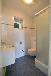 a bathroom with a toilet and a sink and a shower at Apartmani Badurina - Maslina in Lun