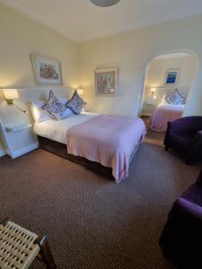 a hotel room with two beds and a chair at Ashe's Accommodation - Room only in Dingle +28 photos