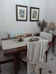 - une table à manger avec une nappe et des chaises blanches dans l'établissement Casa Matzurana, à Kounoupidhianá