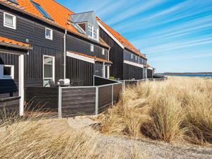 una fila di case nere sulla spiaggia di Holiday Home Strandengen a Juelsminde