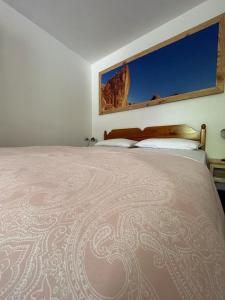 una camera da letto con un grande letto con una montagna sullo sfondo di DOLOMITI HOUSE 12 a Fiera di Primiero