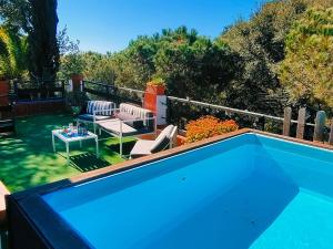 a blue swimming pool with a table and chairs at Villa Neptuno in Tossa de Mar