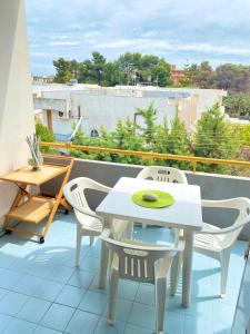 - Balcón con mesa blanca y sillas en Residence Tigli Campomarino, en Campomarino