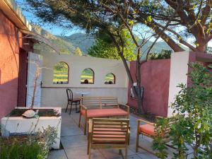 a patio with a table and chairs and a tree at Casa di Floumy in Calvi