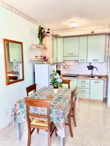 y cocina con mesa, sillas y nevera. en Residence Tigli Campomarino, en Campomarino